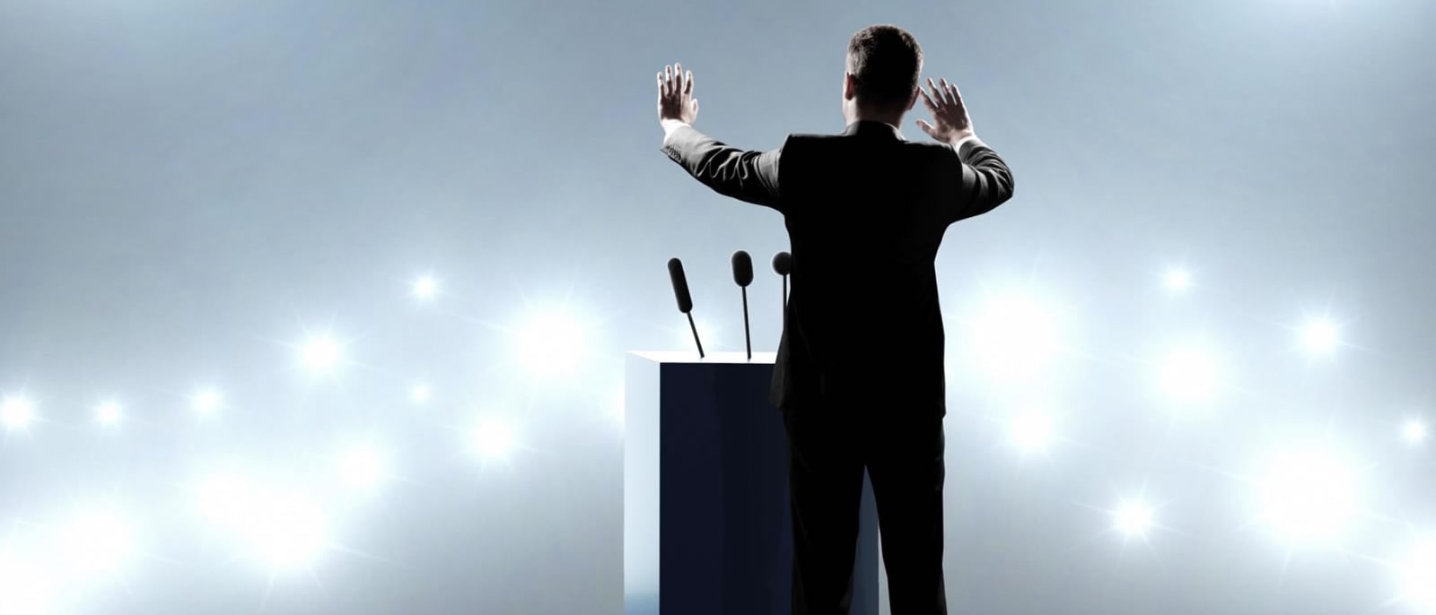 Толпа взрослых мужчин слушает речь на мероприятии внимательно.